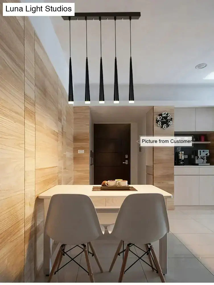 Modern black conical led pendant lamp with sleek tapered shades hangs from minimalist ceiling fixture for kitchen island