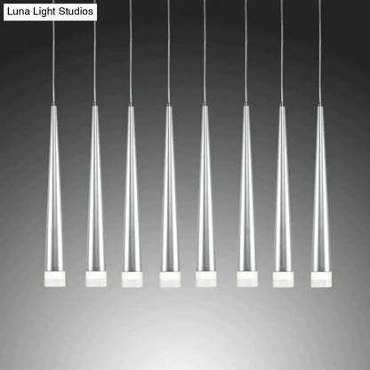 Seven sleek silver-toned modern black conical led pendant lamps with white square bases hang in uniform alignment for kitchen islands
