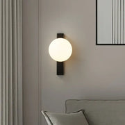 Modern black copper globe led wall sconce with frosted glass globe designed as a bedroom led wall light