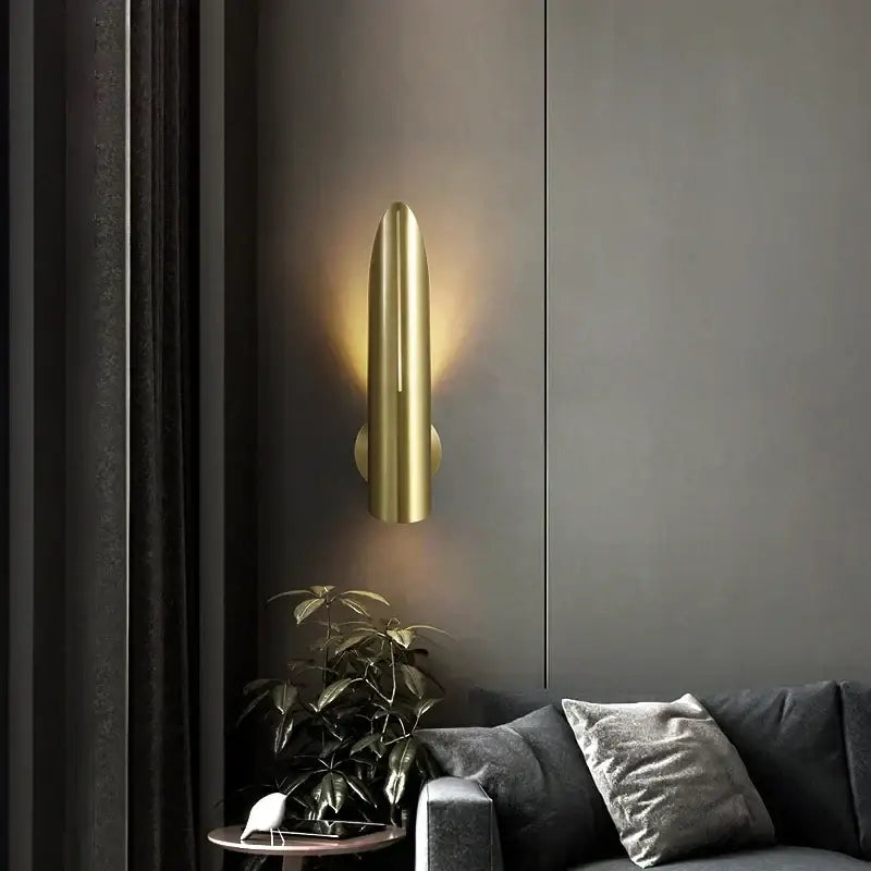 Modern gold-colored sleek cylindrical wall lamp with minimalist design for decorbites black copper luxe living room decor