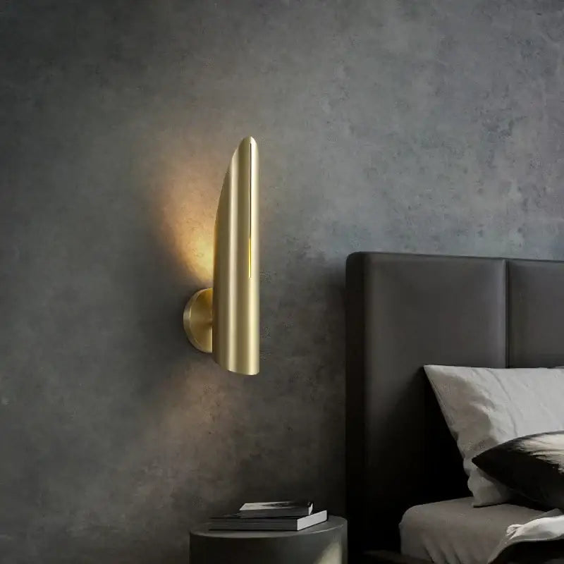 Gold-finished modern wall lamp with sleek elongated curved design in decorbites black copper luxe teardrop sconce style