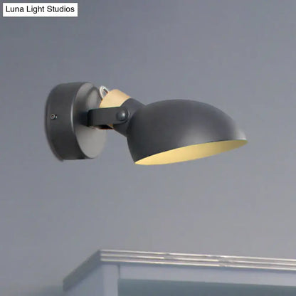 Modern black and cream wall sconce light with matte finish, warm yellow interior, and adjustable arm for bedroom use