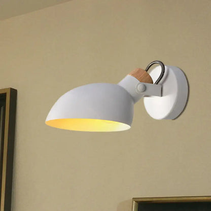 Modern black and cream wall sconce light with wooden accent and warm yellow glow in a stylish bedroom lamp design