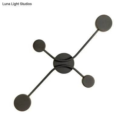 Modern black matte wall lamp with four circular LED lights arranged in a symmetrical star pattern for living room use