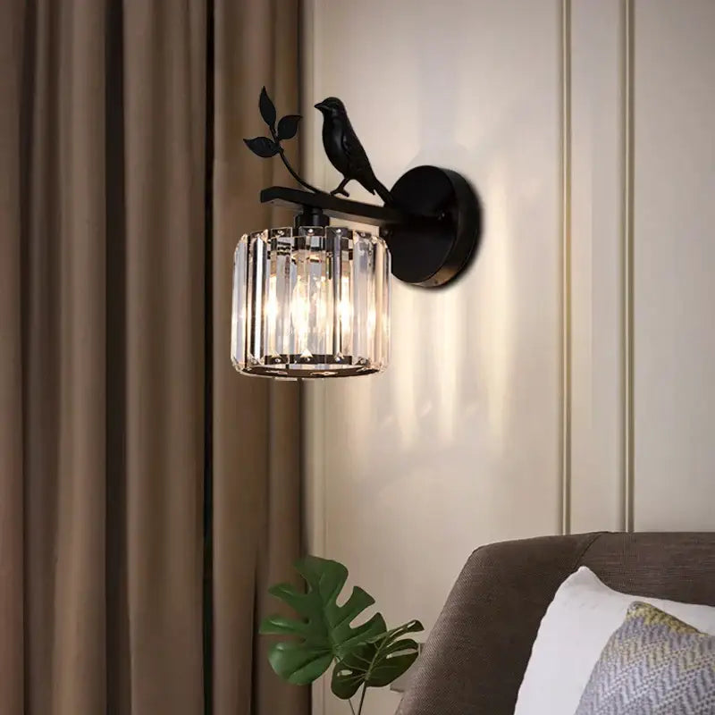 Modern black crystal bird wall lamp featuring a wrought iron sconce with a crystal cage and perched bird decorbites crystal bird