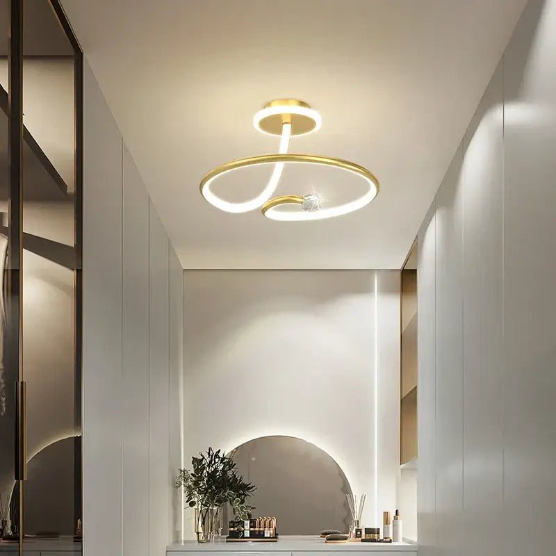 Modern black crystal chandelier with gold-toned ceiling light featuring two interlocking rings and central crystal accent