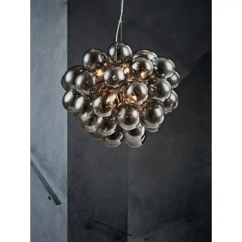 A modern black decorbites crystal grape chandelier with reflective dark-tinted glass bulbs for dining room pendant light