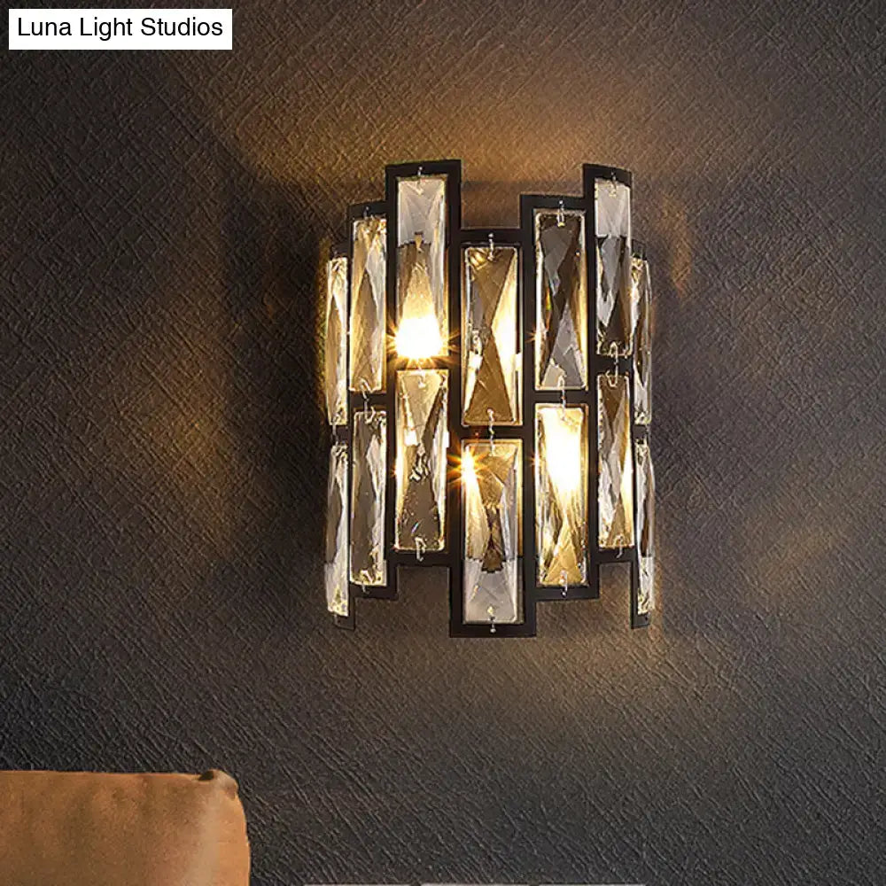 Modern black crystal half cylinder wall lamp featuring faceted clear panels that refract warm light for living room use