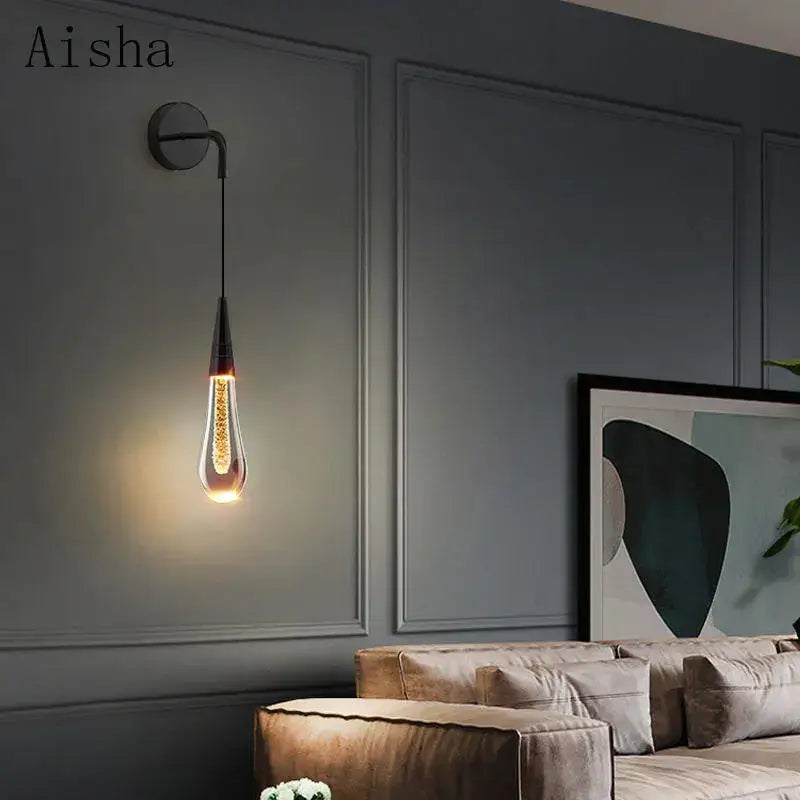 Modern black crystal led wall lamp featuring an Aisha teardrop pendant with clear glass and dark metal accents