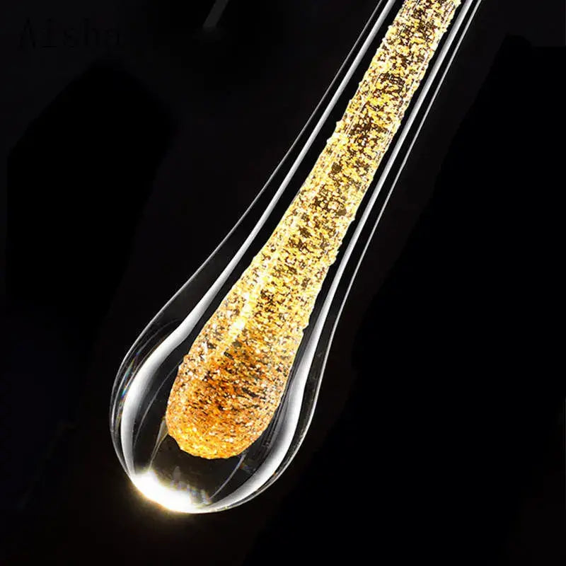A sleek modern black crystal led wall lamp with a transparent teardrop glass pendant and glowing golden interior decorbites crystal led