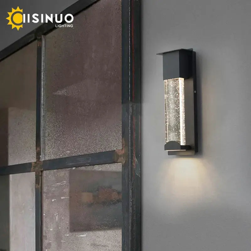 Modern black wall light with clear textured glass panel and pir motion sensor for outdoor use illuminating warmly