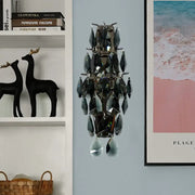 A modern black crystal wall sconce with faceted teardrop elements on a sleek metallic frame for living room use