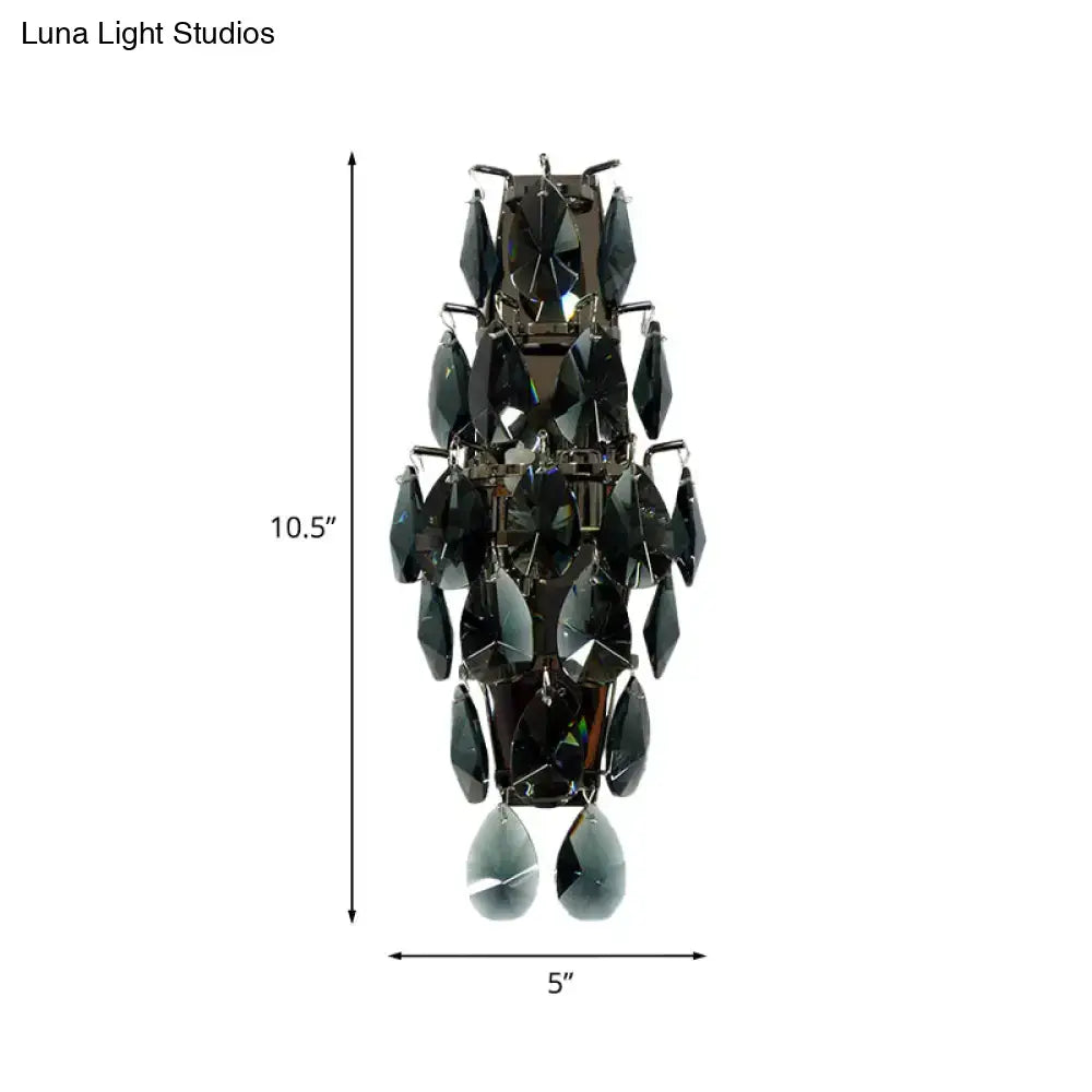 A sleek black crystal wall sconce with tiered teardrop crystals for modern living room gem fixture lighting