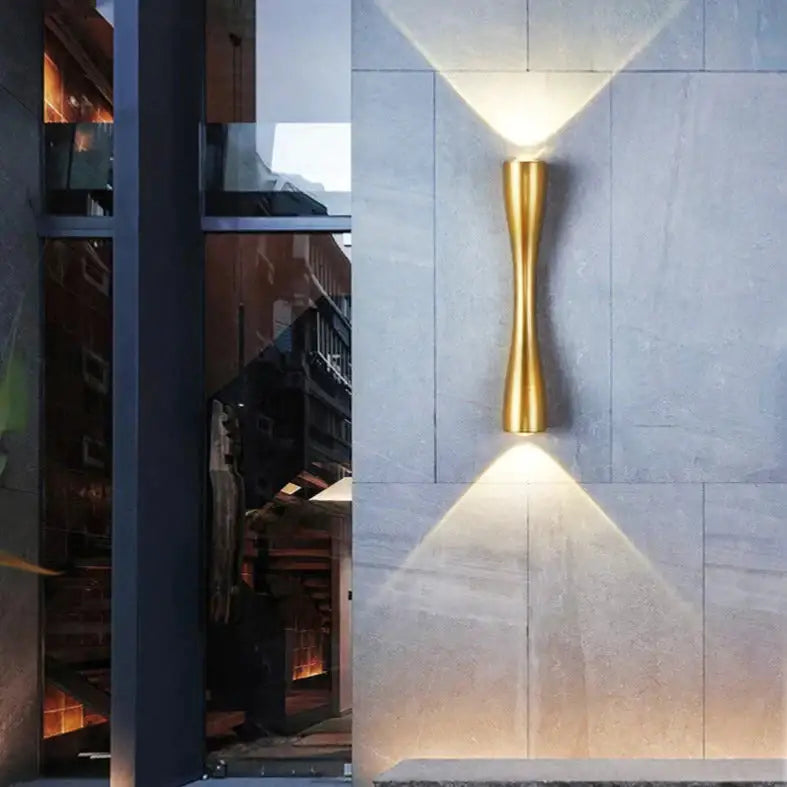 Modern black curved wall sconce with gold-toned sleek design casting warm light for outdoor waterproof porch use