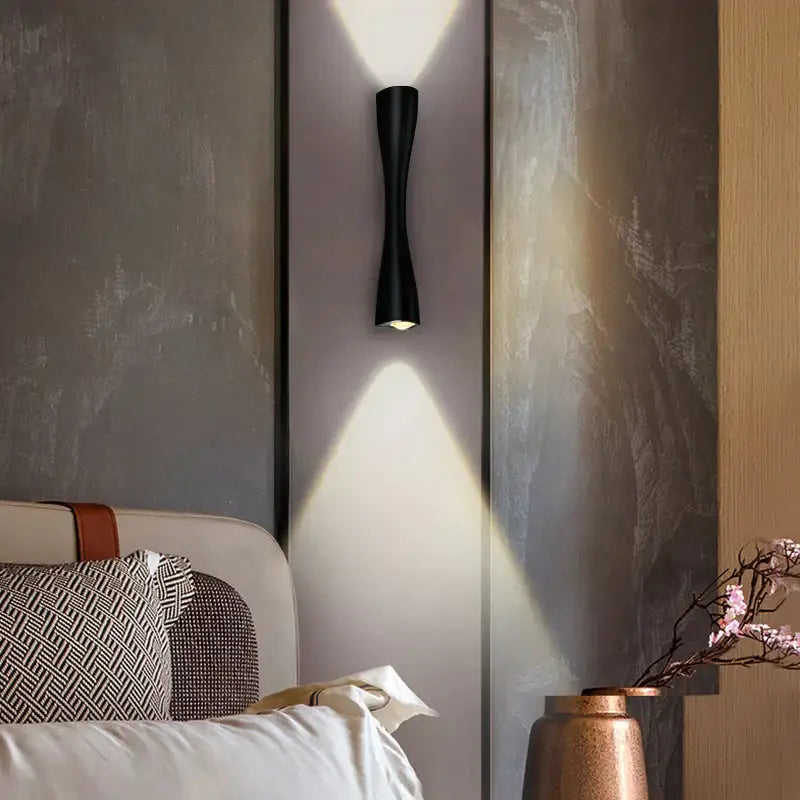 Modern black curved wall sconce with sleek design casting focused light for outdoor waterproof porch use