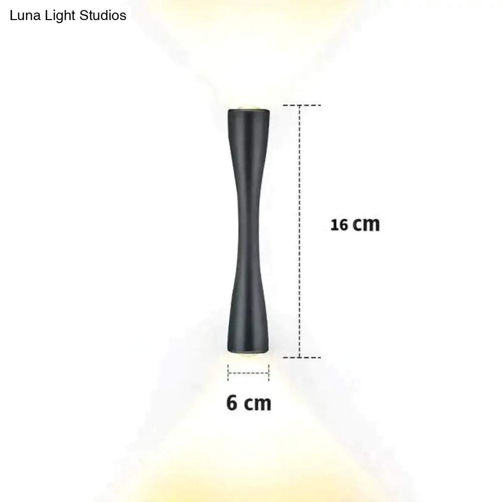 A sleek matte black modern curved wall sconce with hourglass silhouette 16 cm tall for outdoor porch lighting