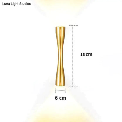 A sleek gold-colored brass wall sconce 16 cm tall with an hourglass shape for modern outdoor porch lighting