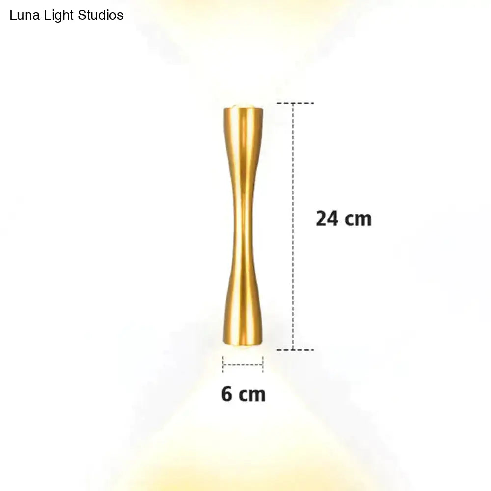 A sleek gold-toned metallic floor lamp 24 cm tall with a slender hourglass design for modern indoor use