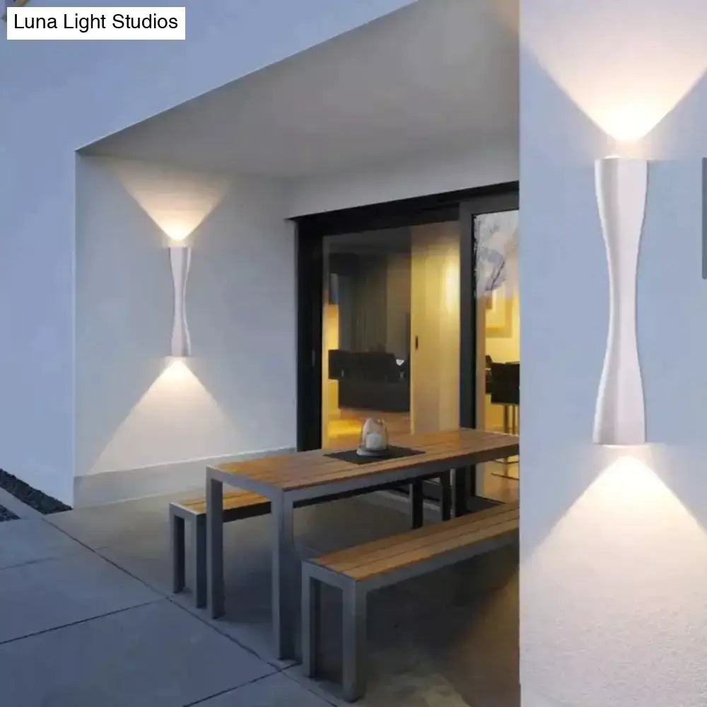 Modern black curved wall sconce outdoor waterproof porch light with sleek white sculptural design casting warm light