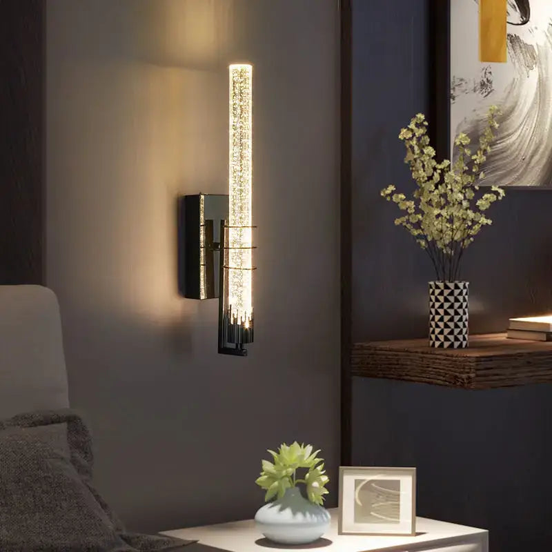 Modern black decorbites crystal wall light featuring an illuminated glass tube with sparkling crystals for bedroom use