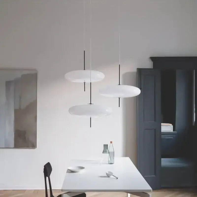 Modern white disc-shaped pendant light with black slender cords by decorbites designer iron for dining room and bar decor
