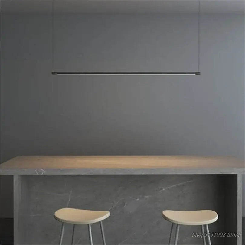 Modern black dimmable led pendant light in minimalist linear design suspended above wooden dining room countertop decorbites black dimmable