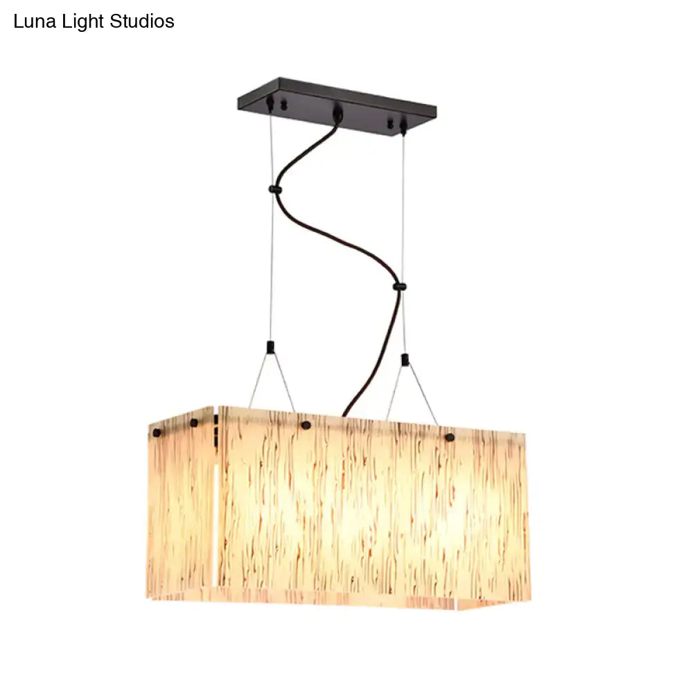 Rectangular pendant light with amber glass shade and dark bronze metal hardware featuring adjustable cord length and e26 bulb base