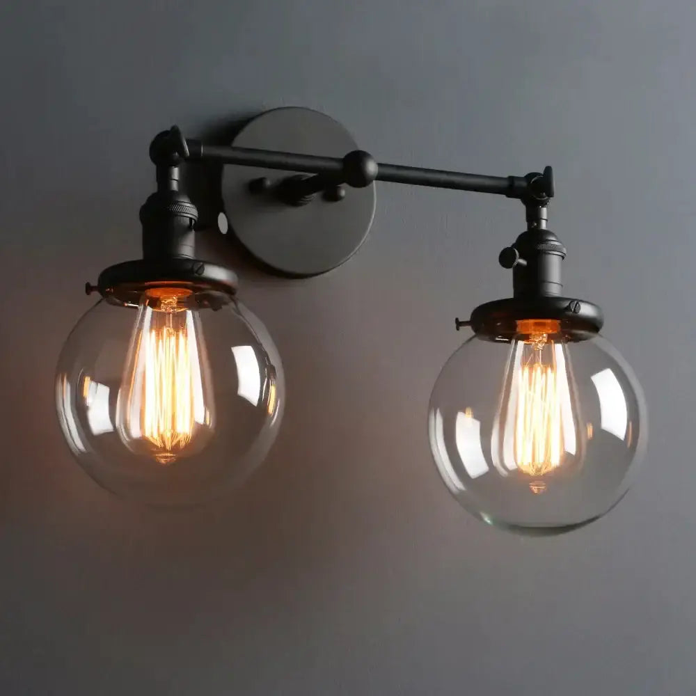 Modern black double ball heads globe glass wall sconce with two warm edison bulbs on metal arm and circular base for bedroom light