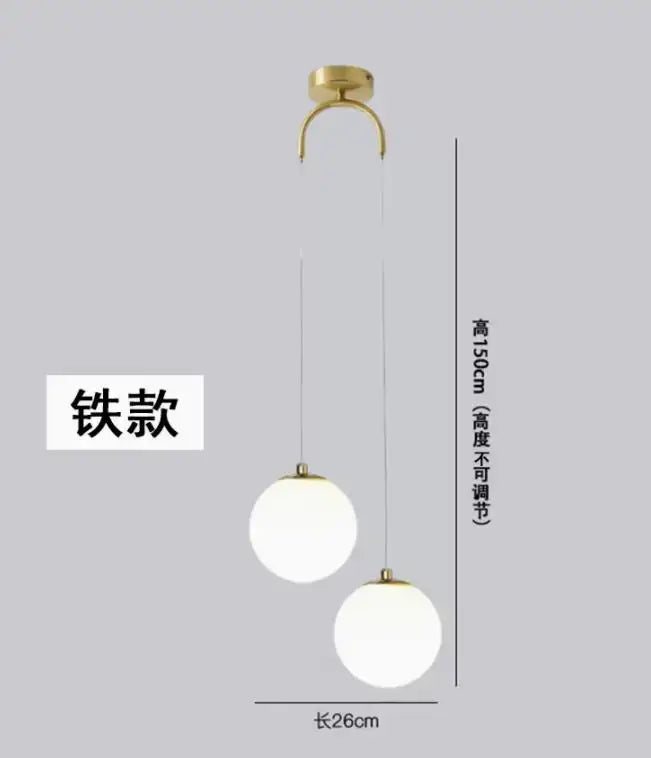Gold-finished metal pendant light with double glass ball frosted globes hanging from curved ceiling mount for bedroom