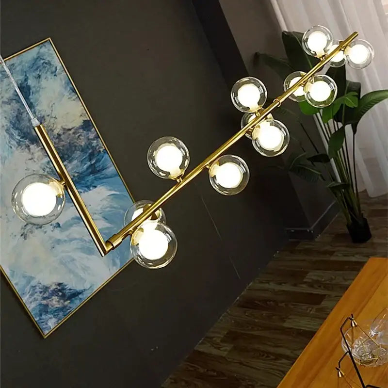 Gold-toned modern double glass lampshade chandelier with clear glass globe bulbs for dining room lighting
