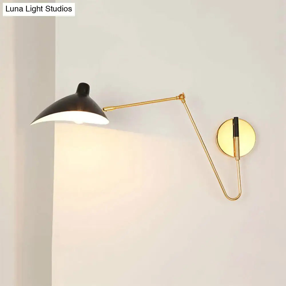 Gold-toned wall lamp with a black duckbill shade and curved articulated arm for modern bedroom sconce lighting