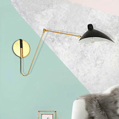 Black and gold modern wall lamp with duckbill shade and curved arm articulated for bedroom use