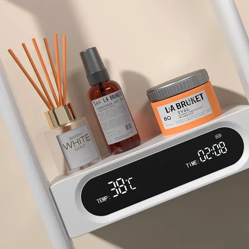 Modern black electric showerhead knobs column faucet displayed with orange la bruket diffuser and amber spray bottle