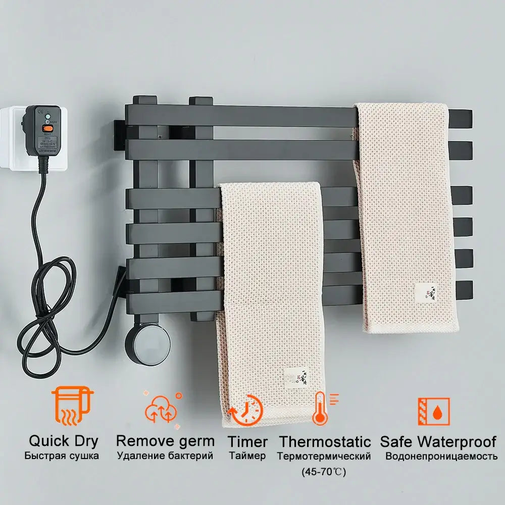 Modern black electric towel warmer rack with horizontal bars and power cord plugged into wall outlet for bathroom use