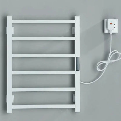 White electric towel warmer with sleek minimalist design and matching power cord plugged into outlet for bathroom use