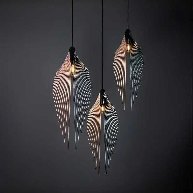 Three modern black flying wing shape pendant lights with metallic feather design and warm glowing bulbs for living room