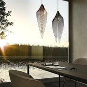 Two sleek black metal pendant lights with flying wing shape fins hang over a modern living room table