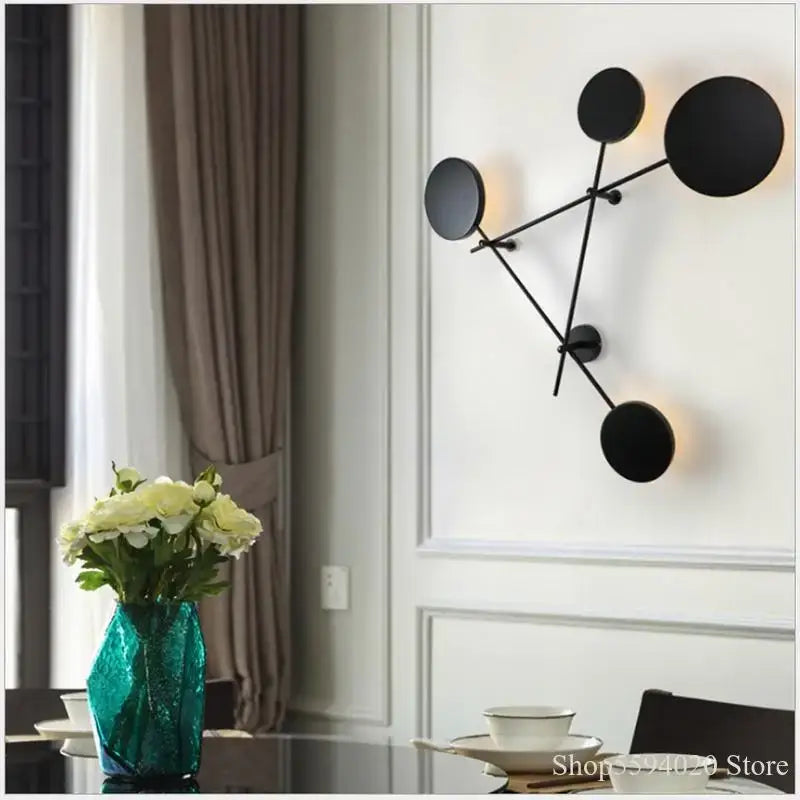 Modern black geometric iron wall lamp featuring interconnected rods and illuminated discs for living room decorbites geometric iron wall