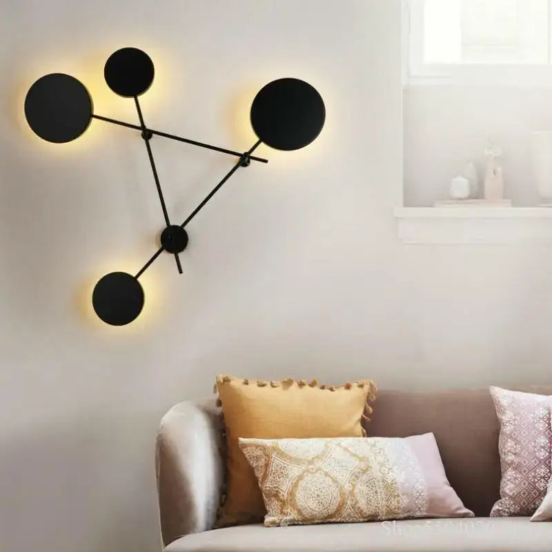 Modern black geometric iron wall lamp with circular sconce and warm glowing light for living room decorbites geometric iron wall