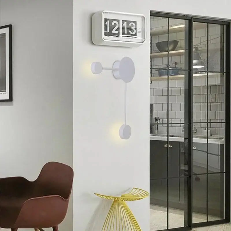 White rectangular flip clock with black numerals showing 12 13 beside modern black geometric led wall lamp bedroom sconce