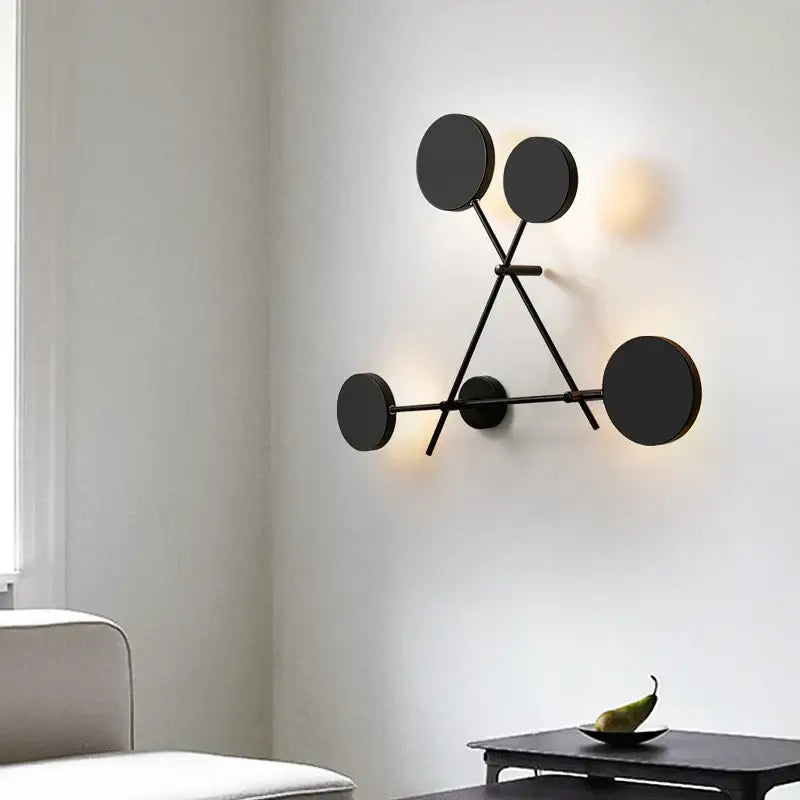 Modern black geometric led wall lamp with circular light fixtures in a minimalist tripod design for living room use