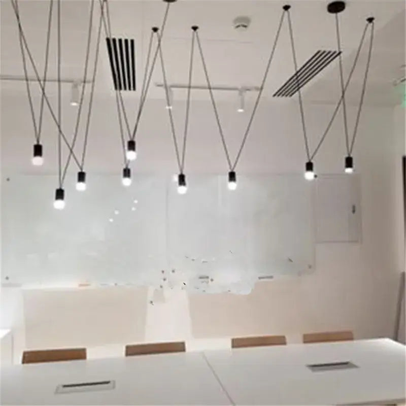 Modern black geometric led wire pendant light with slender cords hanging in a minimalist office decorbites geometric led chandelier