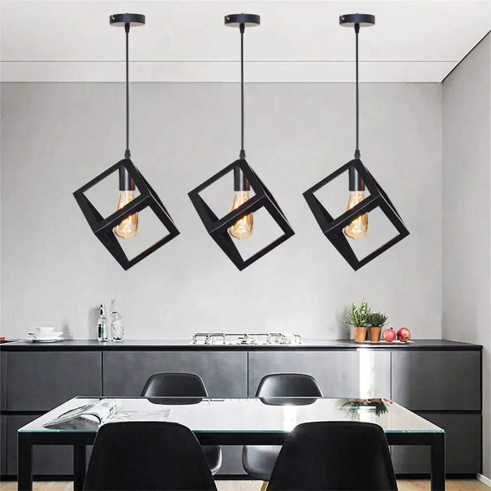 Modern black geometric pendant light with three exposed filament bulbs hangs above a kitchen island decorbites black geometric
