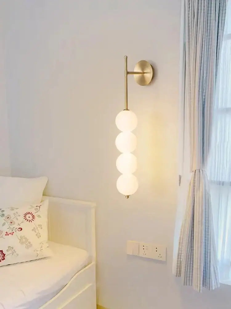 Modern wall sconce with brass-finished metal arm and four frosted glass spheres for decorbites glass ball led lighting