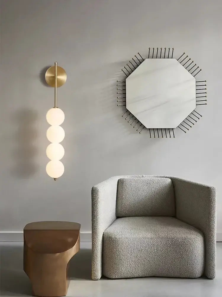 Modern black glass ball led wall sconce mounted beside a plush gray armchair with textured fabric for living room decorbites glass ball wall sconce