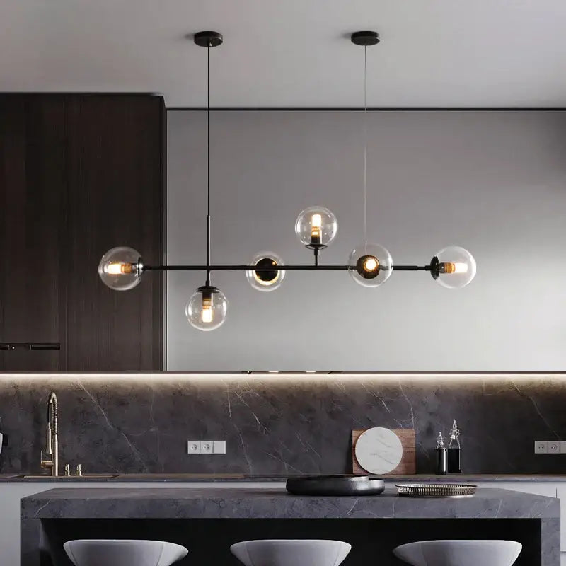 Modern black metal chandelier with decorbites glass ball pendant lamps featuring clear glass globe shades for dining room decor