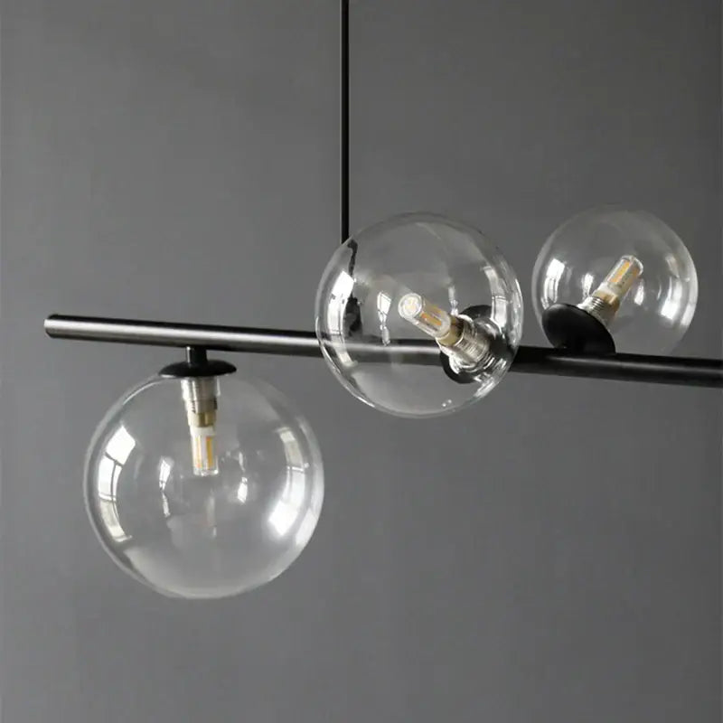Modern black metal pendant light with three clear glass ball shades suitable for dining room decorbites glass ball pendant