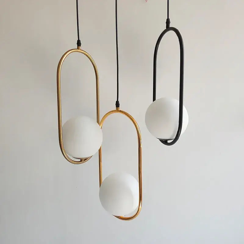 Modern black glass ball pendant lights set of 4 with gold and black curved metal frames and white spherical glass globes
