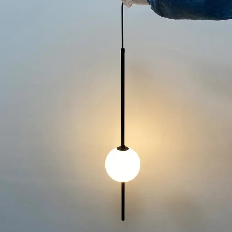 Minimalist modern black glass ball pendant lights with a glowing white spherical bulb for dining room decorbites pendant lights
