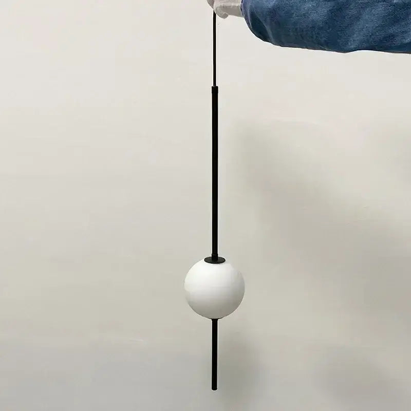 Minimalist white glass ball pendant light with sleek black rod and base ideal for modern dining room decorbites pendant lights
